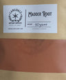 Brown package with a white label featuring 'Madder Root' branding on a textured surface.