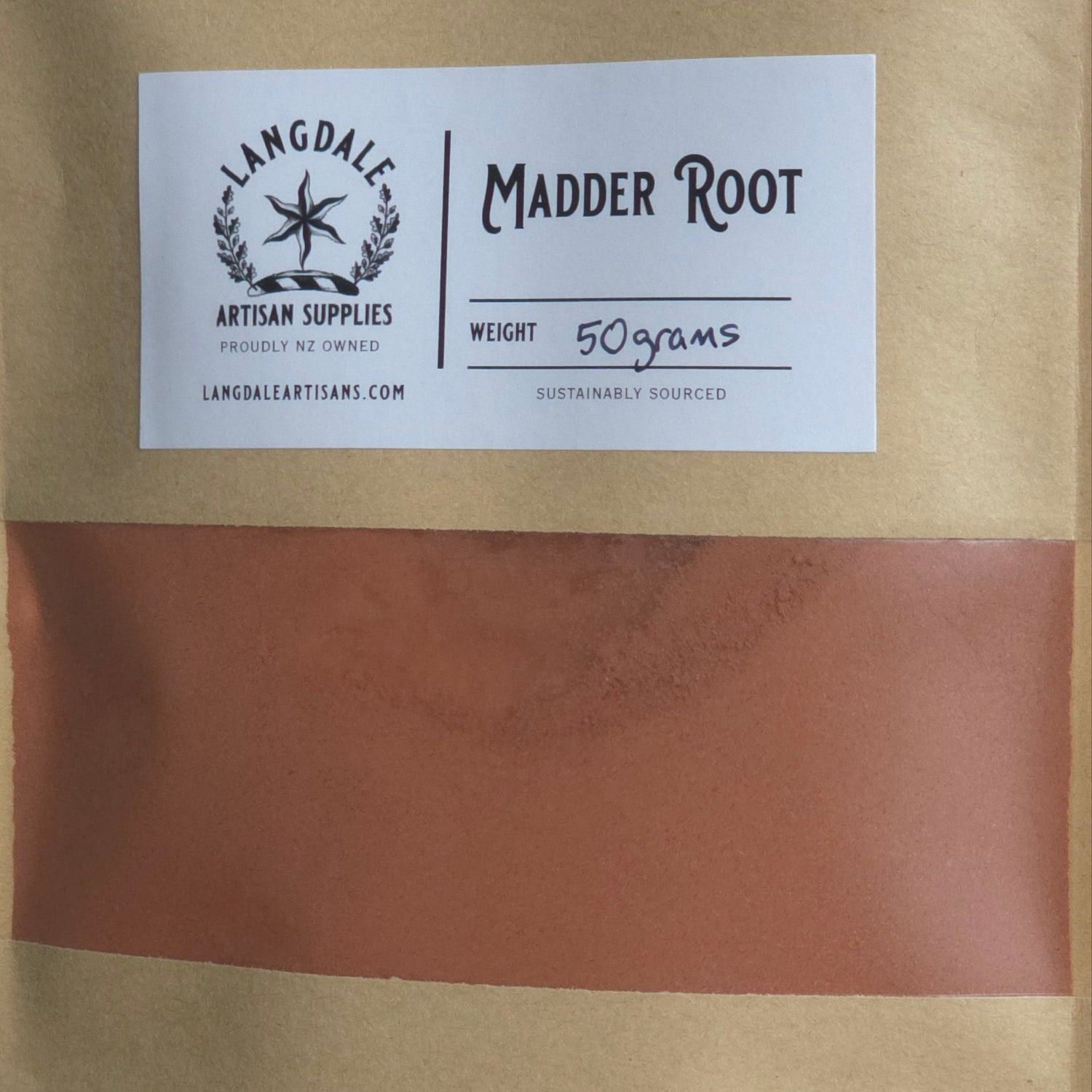 Brown package with a white label featuring 'Madder Root' branding on a textured surface.